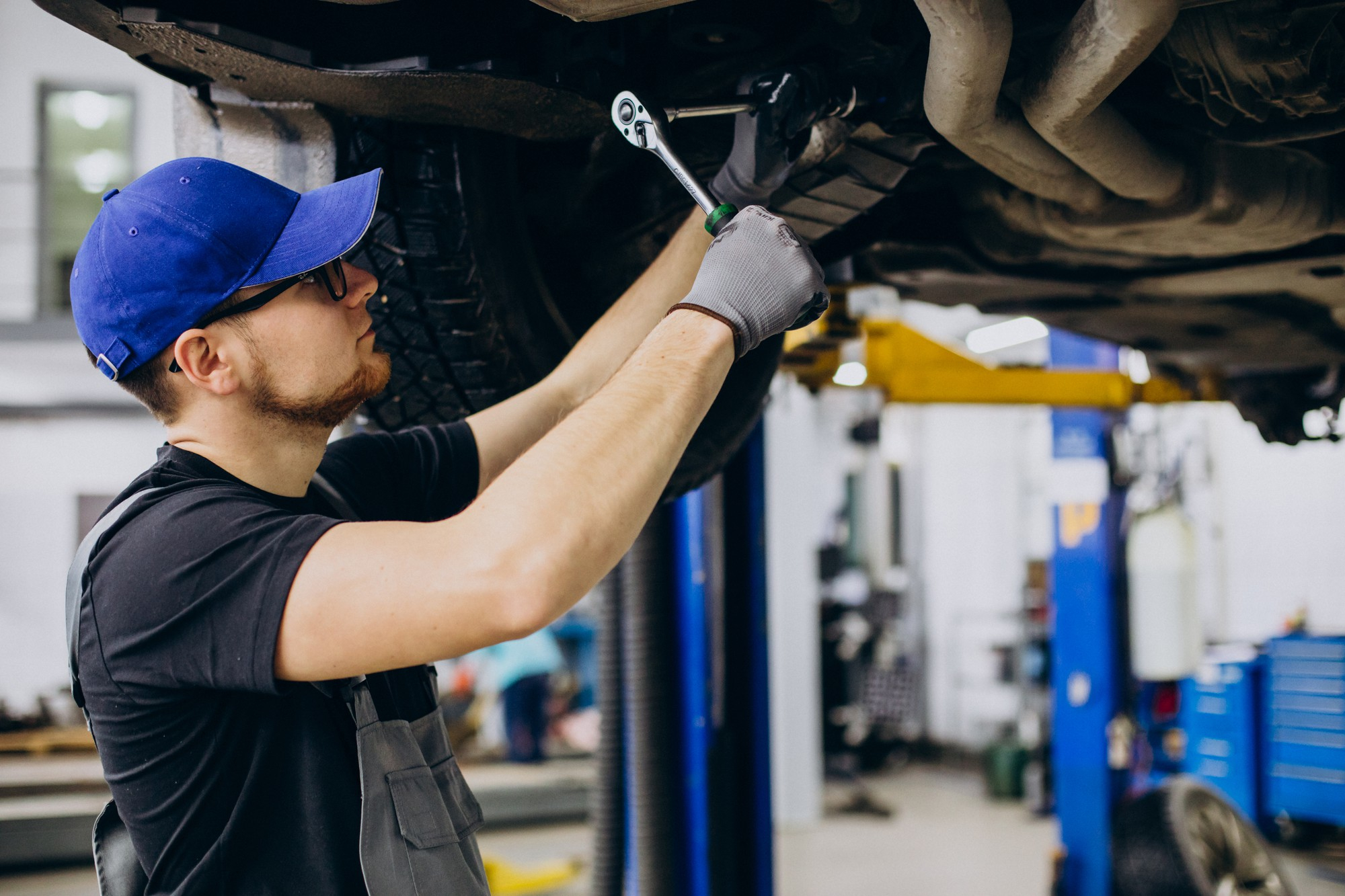 Mechanic inspecting car's undercarriage for faults